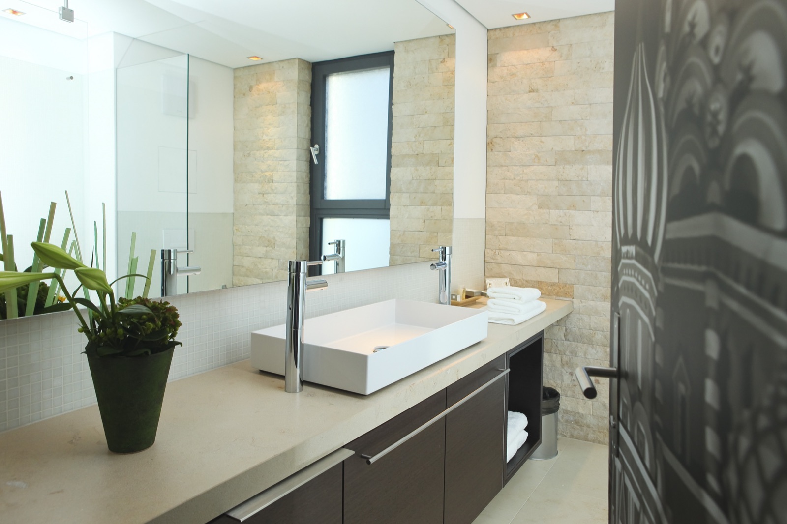 Modernes Bad mit Natursteinwand und freistehendem Waschbecken